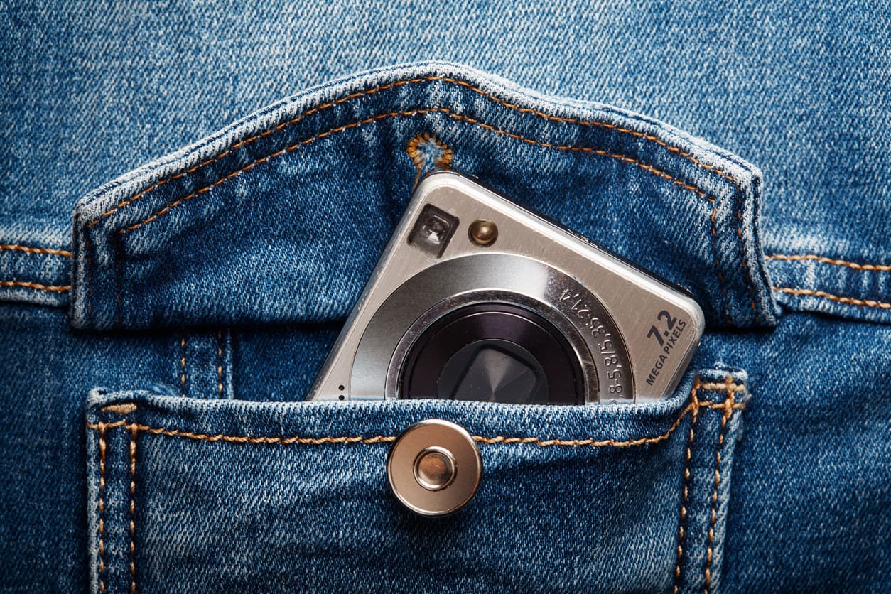 Una cámara compacta dentro del bolsillo de un pantalón vaquero.