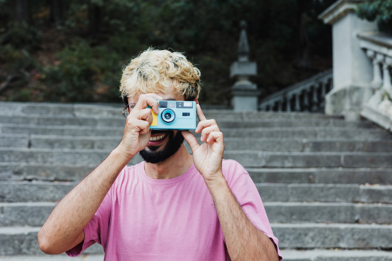 Un chico utiliza una cámara digital compacta para sacar una fotografía.