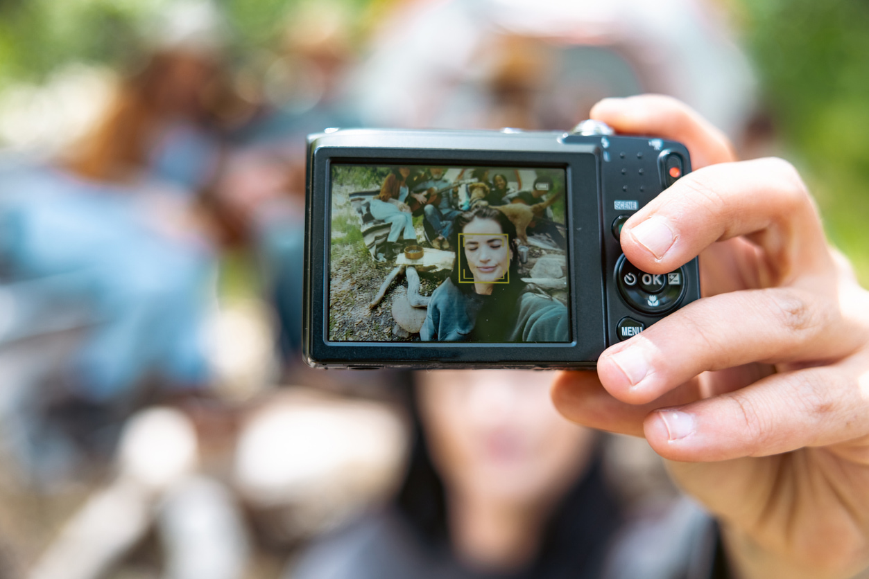Una mujer utiliza una cámara digital para sacar un selfie.