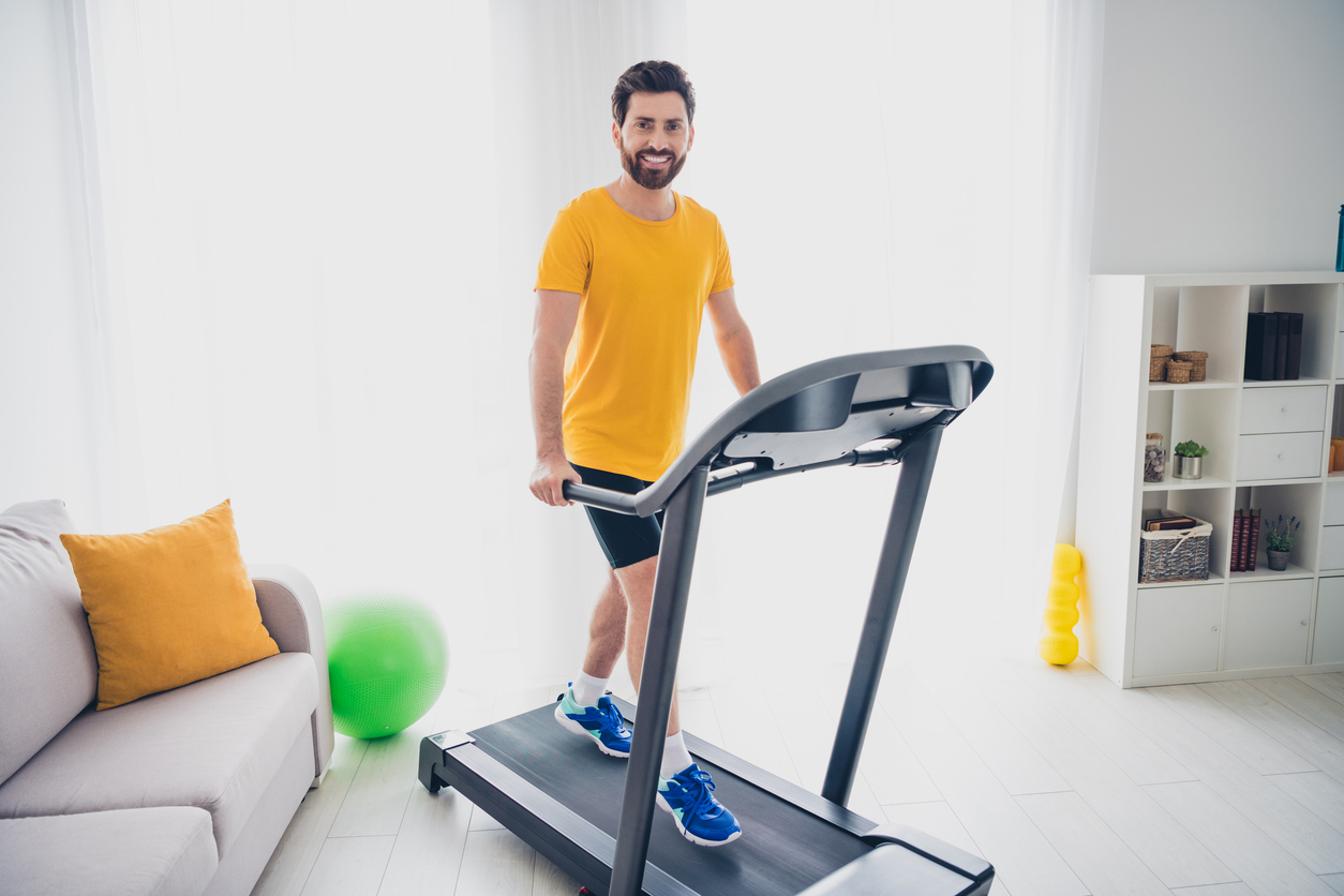Un hombre hace deporte en su cinta de andar.