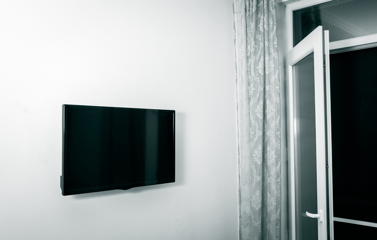 Un televisor pequeño colocado en la pared de una habitación de casa.